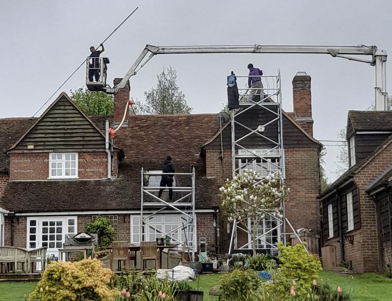 The Moss Cleaners using cherry picker and scaffolding to clean roof safely and professionally in Steyning, West Sussex
